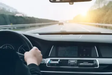 Disfruta de la carretera en plenitud con los mejores servicios de la automoción Vision de las manos de persona conduciendo un coche
