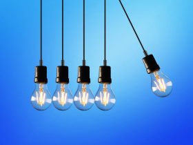 Claves para entender la factura de la luz y ahorrar en electricidad Bombilla encendida sobre fondo de facturas de electricidad representando el ahorro energético