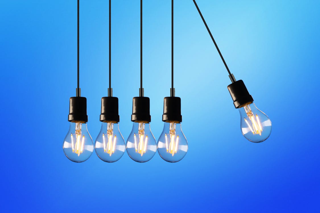 Claves para entender la factura de la luz y ahorrar en electricidad Bombilla encendida sobre fondo de facturas de electricidad representando el ahorro energético