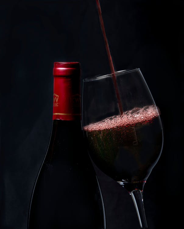 Copas de vino tinto con viñedos al fondo