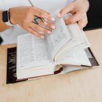 Persona estudiando idiomas con libros y auriculares en su escritorio