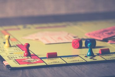 Juegos de mesa para adultos: los más divertidos para quedar con amigos Grupo de amigos jugando a juegos de mesa en una mesa con snacks